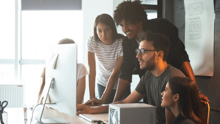 A diverse team of entrepreneurs at a European startup collaborating on innovative applications for AI and Blockchain technologies.