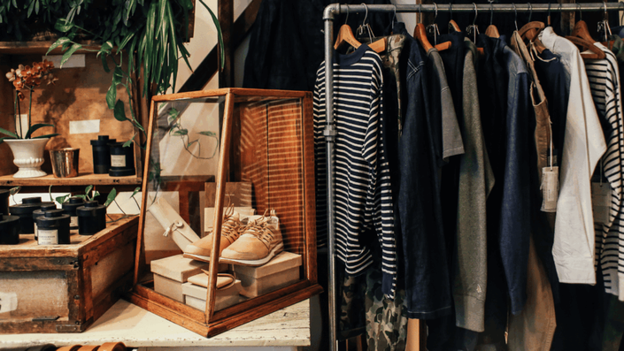 A minimalist fashion boutique with a rack of ethically sourced clothing in natural fabrics, representing stylish and sustainable Eco-Friendly Business Ideas.