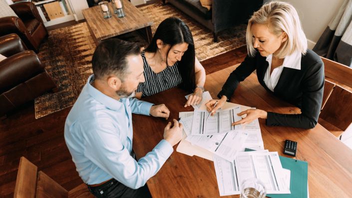 Financial advisor discussing low-risk investment options with a French couple planning their portfolio.