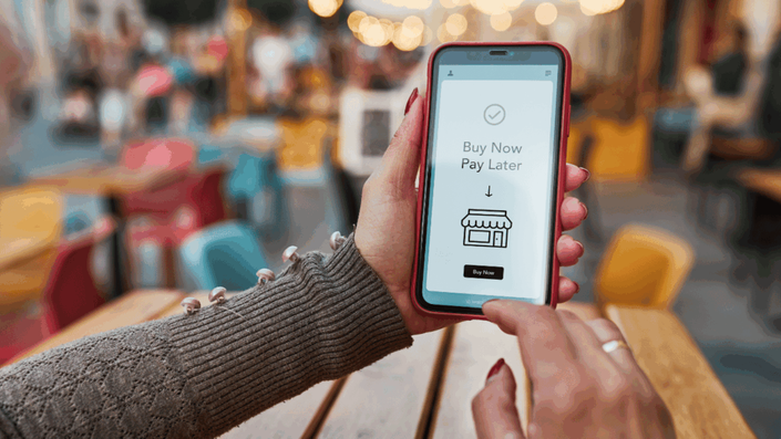 Mobile phone displaying a Buy Now Pay Later payment plan for an online purchase.