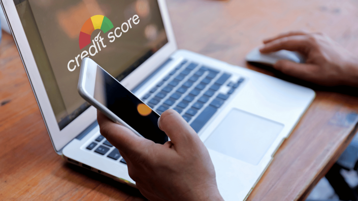 Person reviewing financial documents and calculating their credit score, evaluating spending habits and financial health.