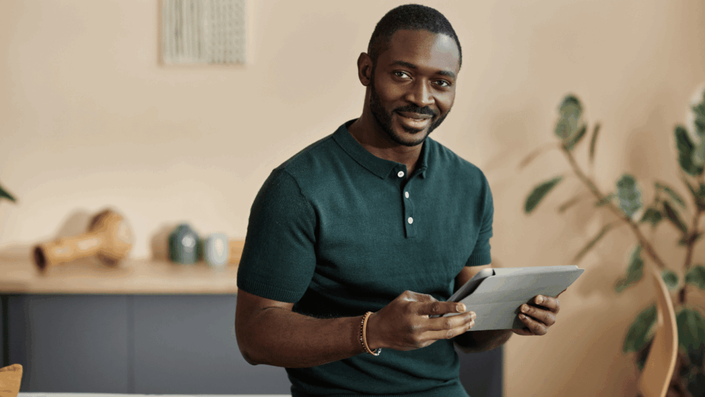 A confident modern investor holding a tablet, illustrating the rise of digital finance and accessible platforms for making French investments.
